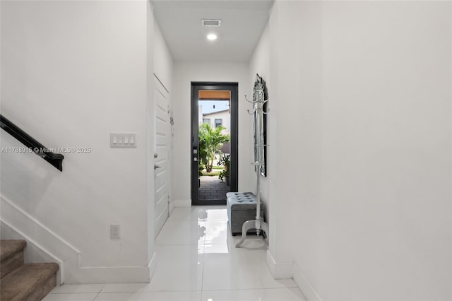 doorway featuring baseboards, tile patterned floors, stairs, and visible vents