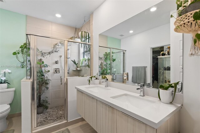 bathroom featuring a stall shower, a sink, and toilet