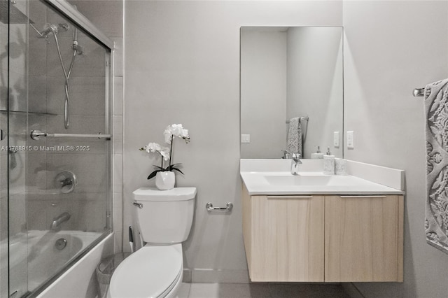 full bath featuring baseboards, toilet, vanity, and enclosed tub / shower combo
