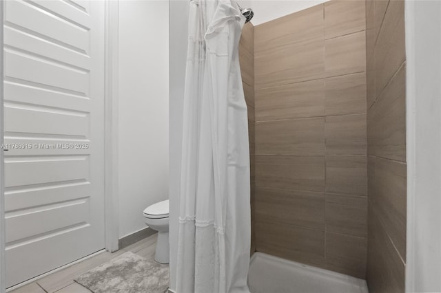 bathroom with tiled shower and toilet