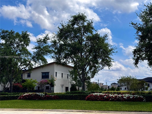 view of side of property featuring stucco siding and a yard