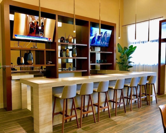 bar featuring a community bar and wood finished floors