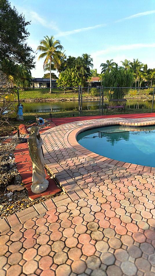 pool with a patio and fence