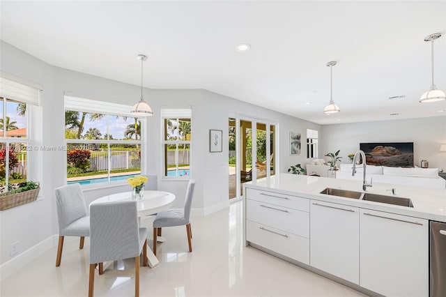 kitchen featuring white cabinets, a sink, baseboards, recessed lighting, and light countertops
