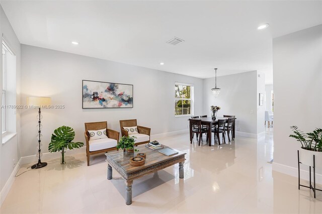 living room featuring baseboards, visible vents, and recessed lighting