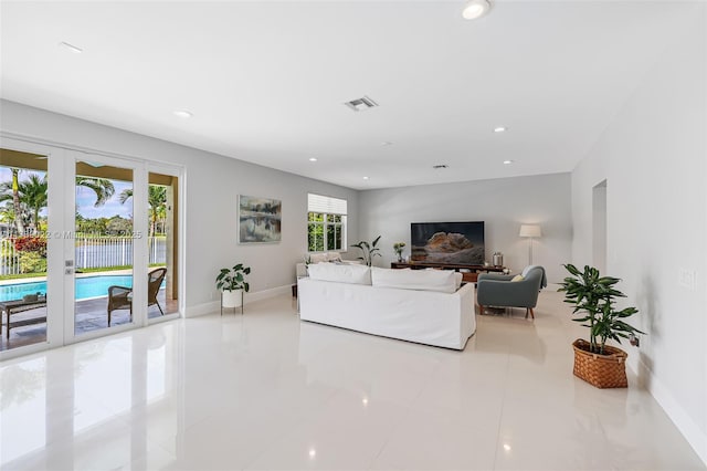 tiled living area with recessed lighting, visible vents, baseboards, and french doors