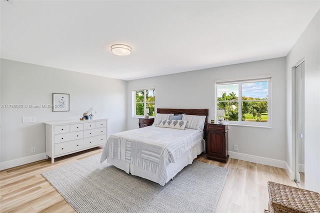 bedroom with light wood finished floors and baseboards