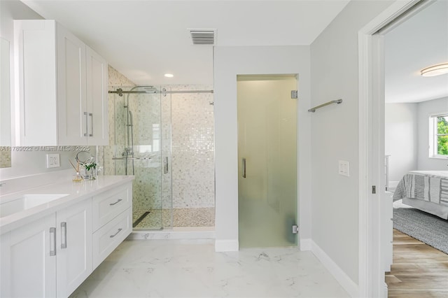 ensuite bathroom featuring ensuite bath, baseboards, visible vents, a shower stall, and vanity