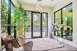 doorway to outside with an inviting chandelier