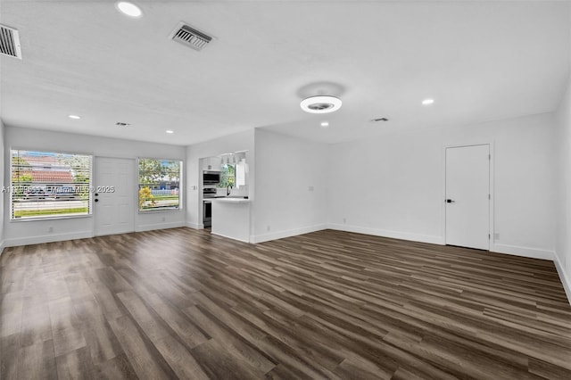 unfurnished living room featuring recessed lighting, visible vents, baseboards, and dark wood-style floors