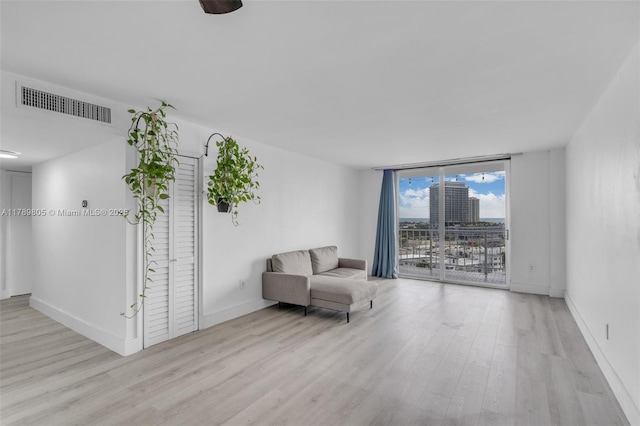 6900 Bay Dr Unit 11F, Miami Beach, FL 33141 - sitting room featuring a wall of windows, baseboards, wood finished floors, and visible vents