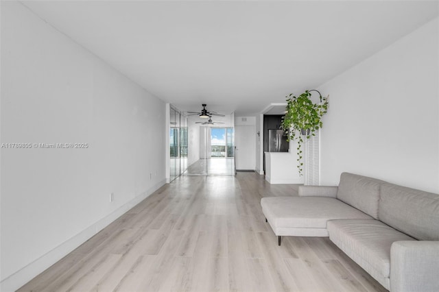 6900 Bay Dr Unit 11F, Miami Beach, FL 33141 - living room featuring baseboards, a ceiling fan, and light wood-style flooring