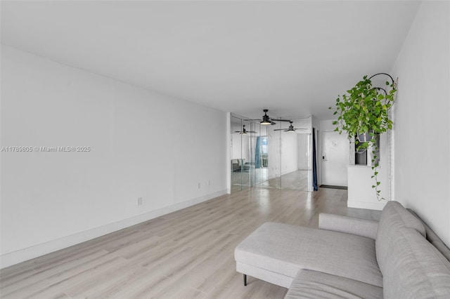 6900 Bay Dr Unit 11F, Miami Beach, FL 33141 - living room featuring baseboards, ceiling fan, and light wood-style flooring