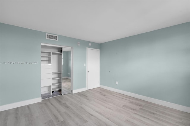 6900 Bay Dr Unit 11F, Miami Beach, FL 33141 - unfurnished bedroom with baseboards, a closet, wood finished floors, and visible vents