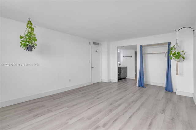 6900 Bay Dr Unit 11F, Miami Beach, FL 33141 - unfurnished bedroom with connected bathroom, baseboards, visible vents, and light wood finished floors