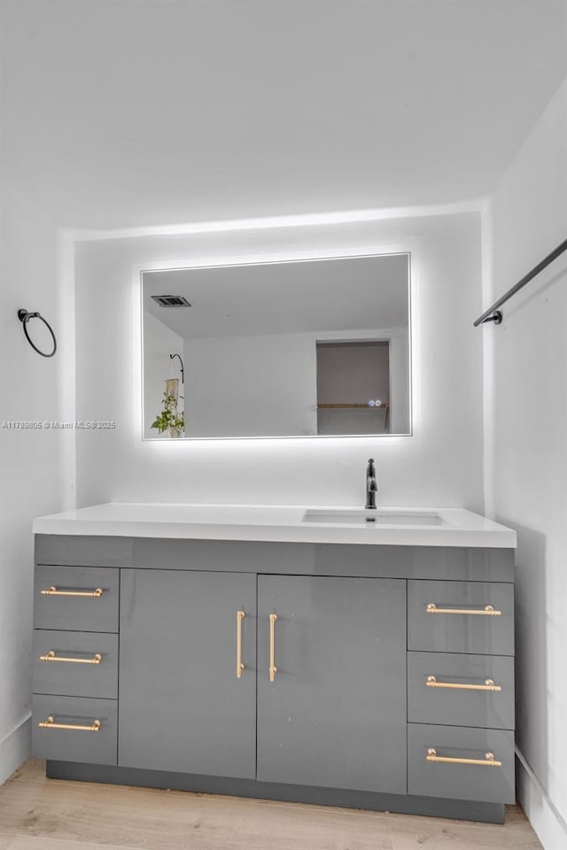 6900 Bay Dr Unit 11F, Miami Beach, FL 33141 - bathroom with vanity, wood finished floors, and visible vents