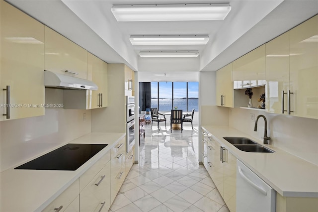 520 Brickell Key Dr Unit A201, Miami, FL 33131 - kitchen featuring a sink, dishwasher, cream cabinets, black electric cooktop, and under cabinet range hood
