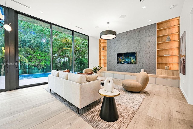 living area with floor to ceiling windows, wood finished floors, a fireplace, and built in shelves