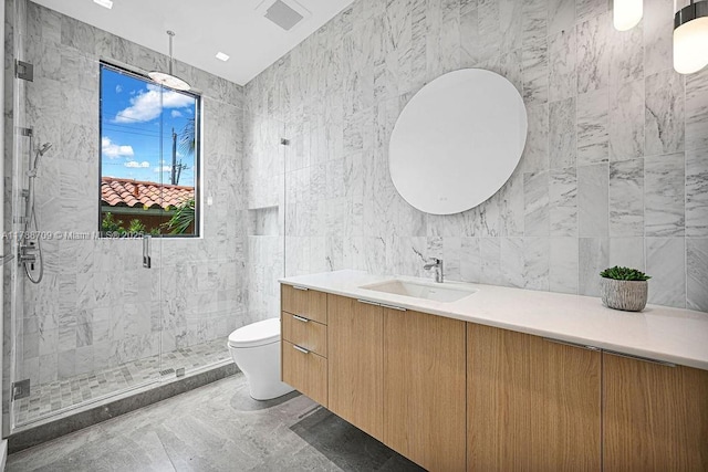 full bathroom with marble finish floor, toilet, vanity, tile walls, and a stall shower
