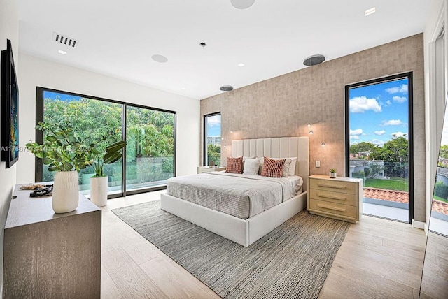 bedroom featuring visible vents, access to outside, and light wood-style floors