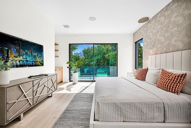 bedroom with visible vents, access to exterior, and light wood finished floors