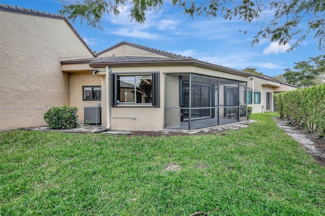 129 Chelsea Ln, Plantation, FL 33324 - back of property with central AC unit, a lawn, fence, stucco siding, and a sunroom