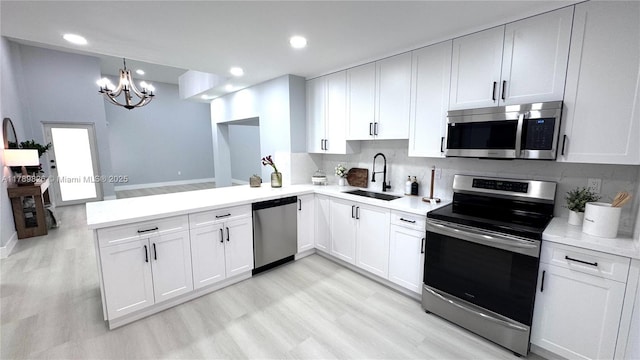 12239 NW 7th St, Miami, FL 33182 - kitchen with stainless steel appliances, a sink, a chandelier, light countertops, and light wood-type flooring