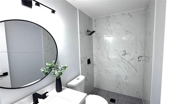 bathroom featuring toilet, vanity, and a marble finish shower
