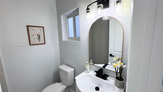 half bathroom featuring toilet and a sink