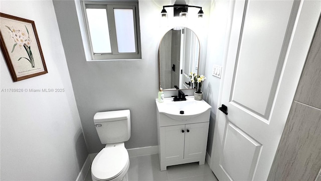 half bathroom with tile patterned floors, vanity, and toilet