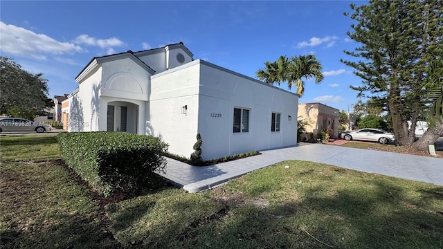view of side of home featuring a yard and stucco siding