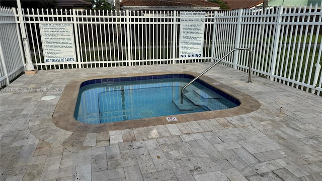 view of pool featuring a patio, fence, and a swimming pool