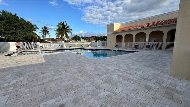 pool with a patio and fence
