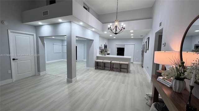 12239 NW 7th St, Miami, FL 33182 - living area featuring a towering ceiling, a chandelier, light wood-style flooring, and baseboards