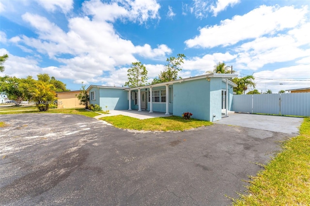 11024 SW 51st Ter, Miami, FL 33165 - view of front of property featuring stucco siding, driveway, a patio, and fence