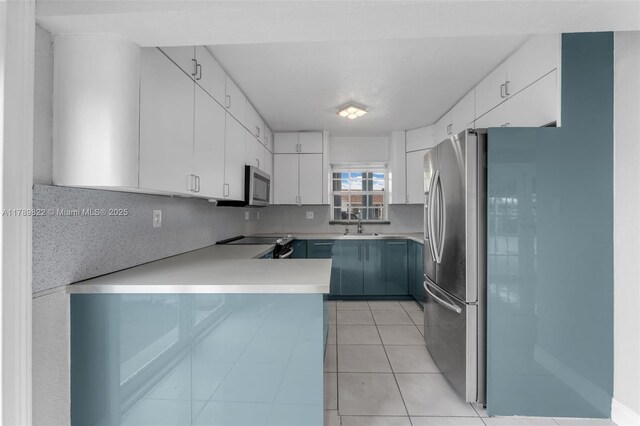 11024 SW 51st Ter, Miami, FL 33165 - kitchen featuring white cabinets, stainless steel appliances, backsplash, light countertops, and a peninsula