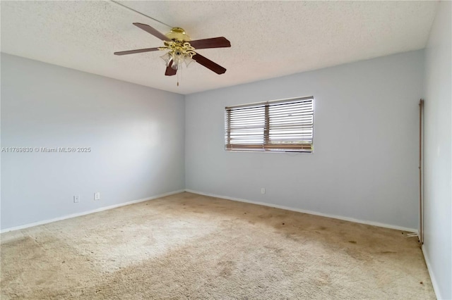 carpeted empty room featuring baseboards, a ceiling fan, and a textured ceiling