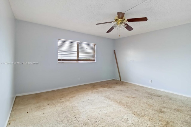 carpeted spare room featuring a ceiling fan, a textured ceiling, and baseboards