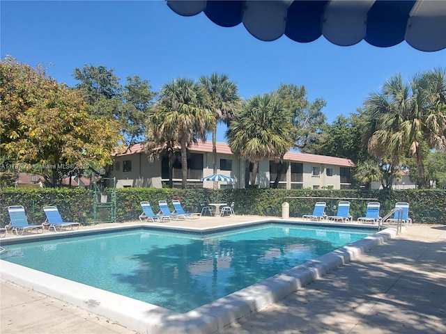 pool with a patio and fence
