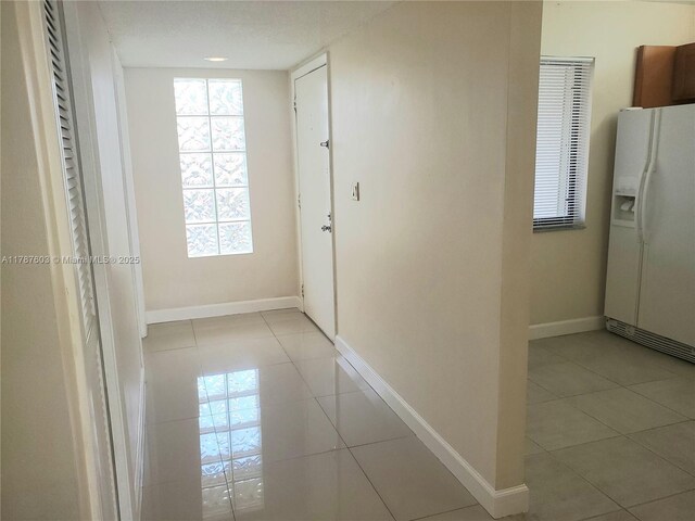 hallway featuring baseboards and light tile patterned floors