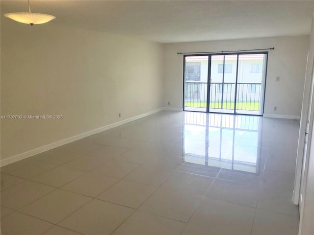 empty room with tile patterned floors and baseboards