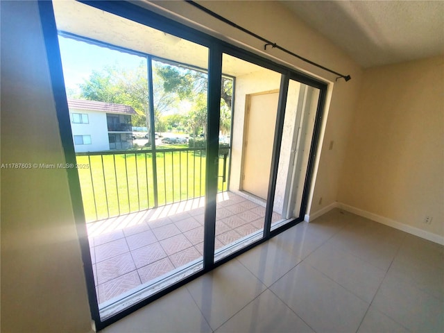 doorway featuring baseboards and tile patterned flooring