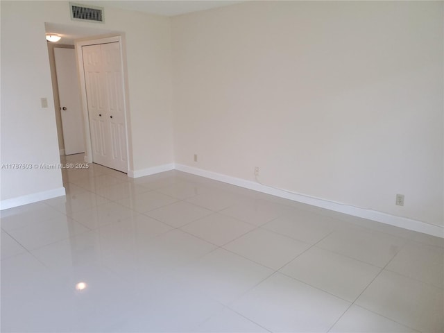 spare room featuring visible vents, baseboards, and light tile patterned floors