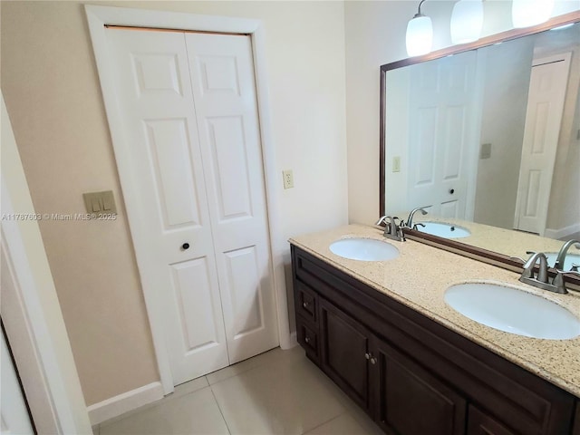 bathroom with tile patterned floors, a sink, and a closet
