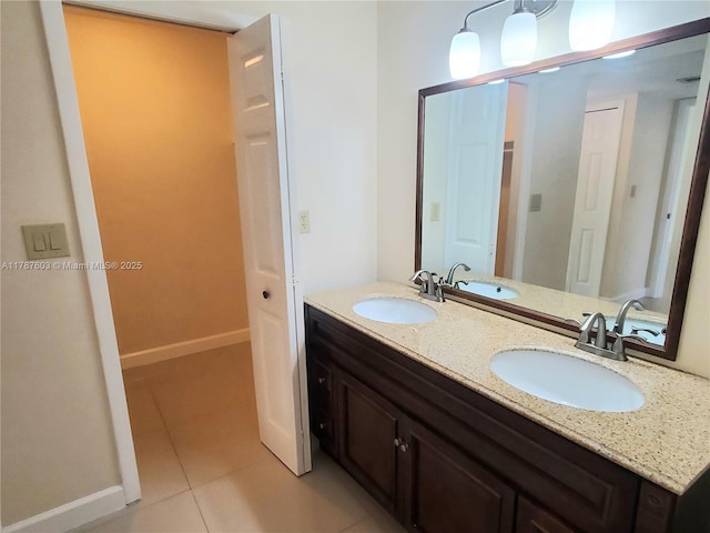 full bath with double vanity, tile patterned floors, and a sink
