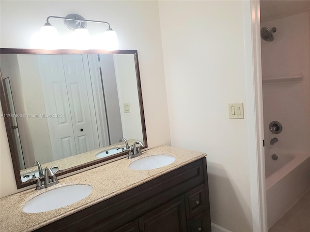 full bath with a sink, double vanity, and shower / bathing tub combination