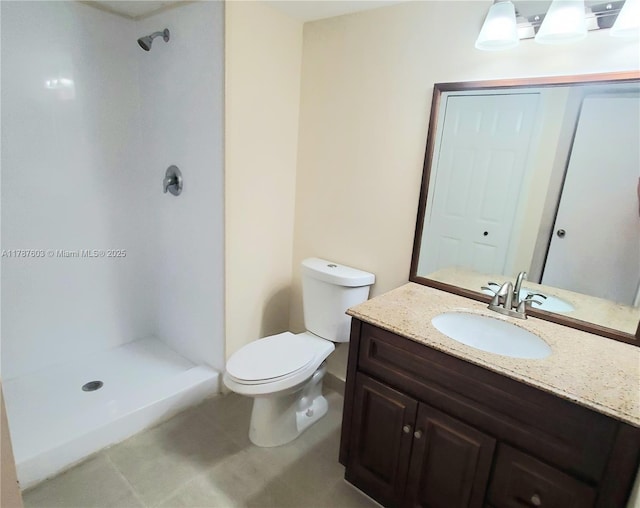 bathroom with a shower stall, toilet, and vanity