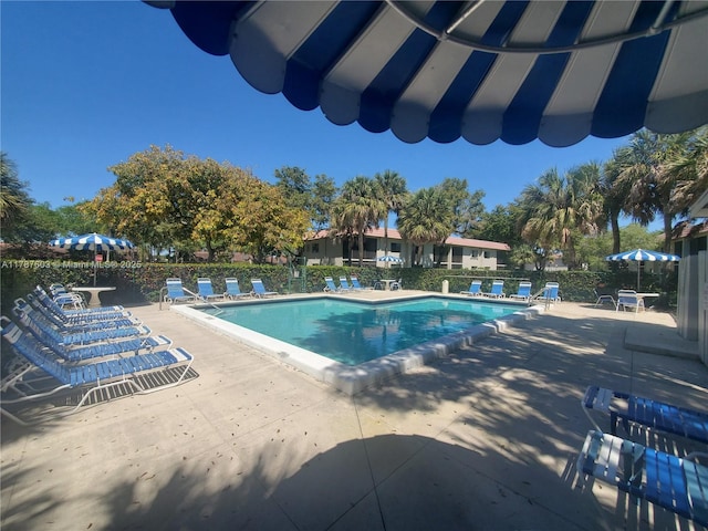 community pool with fence and a patio