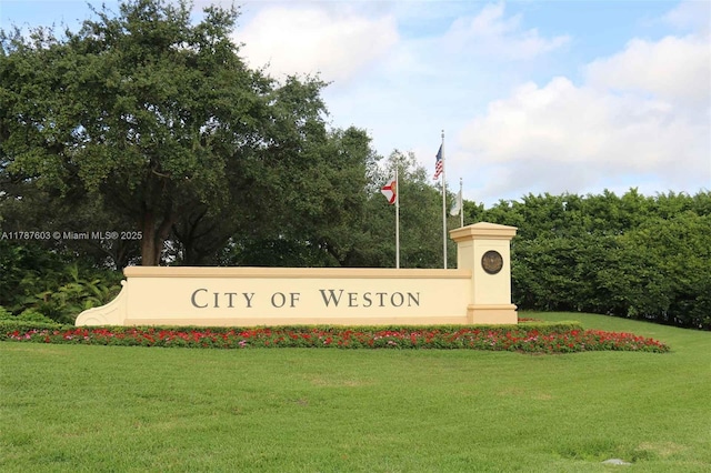 community sign featuring a lawn