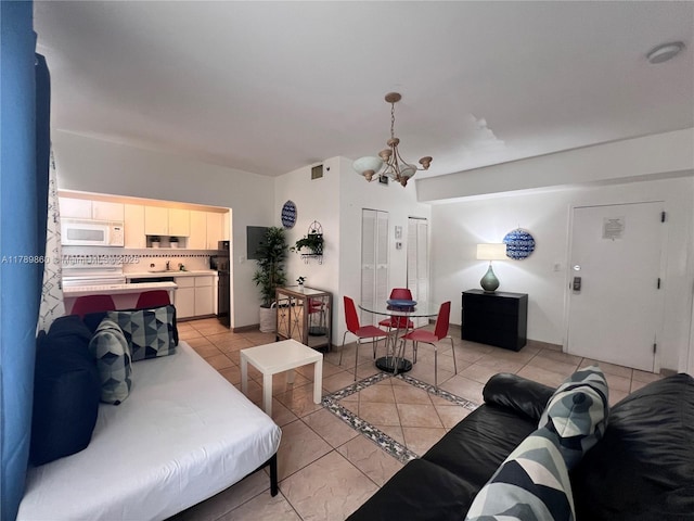 living room featuring light tile patterned flooring, a notable chandelier, and visible vents